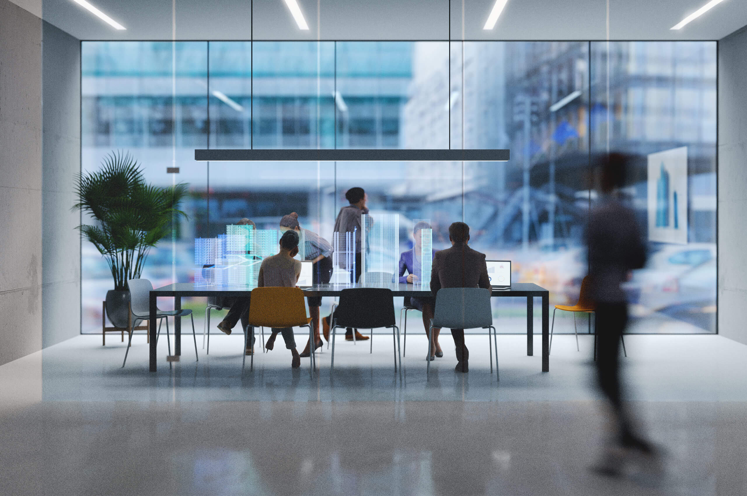 A modern office meeting with people seated around a table, interacting with futuristic holographic skyscrapers. A blurred figure walks past, and a cityscape is visible through the glass walls.