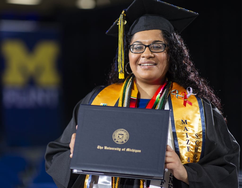 Student holding diploma at a commencement ceremony.